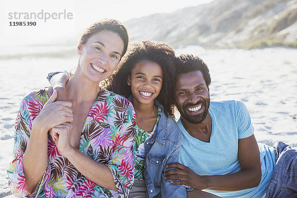 Portrait lächelnde  liebevolle multiethnische Familie am sonnigen Sommerstrand