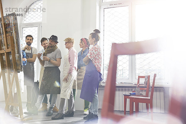 Kunststudenten und Dozenten diskutieren über Malerei im Atelier der Kunstklasse