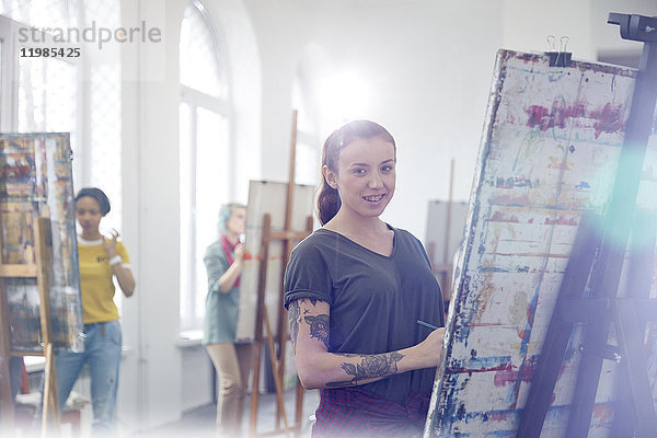 Portrait lächelnde Malerin mit Tattoomalerei im Atelier der Kunstklasse