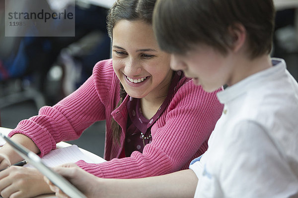 Lächelnde Schüler mit digitalem Tablett im Klassenzimmer