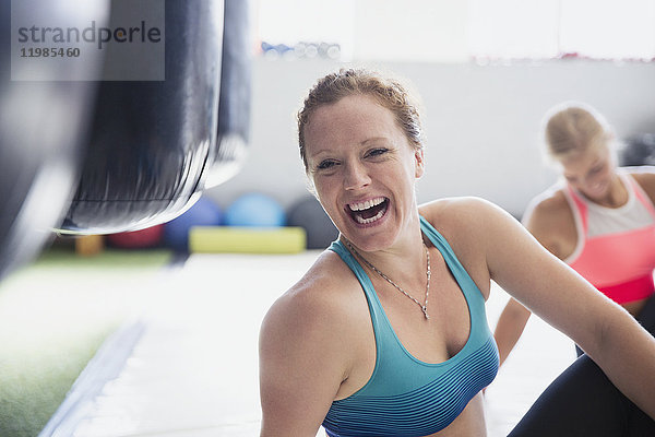 Portrait lachende Boxerin beim Stretching im Fitnessstudio
