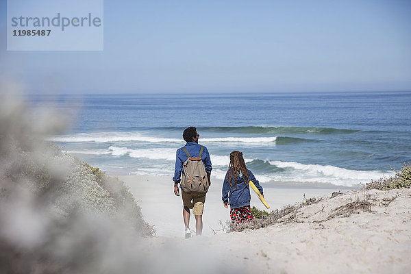 Vater und Tochter wandern mit Boogie-Board am sonnigen Sommerstrand des Ozeans