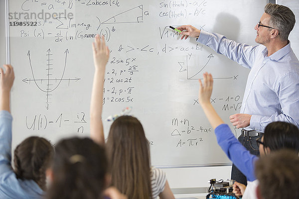 Männlicher Lehrer leitet Physikunterricht am Whiteboard im Klassenzimmer