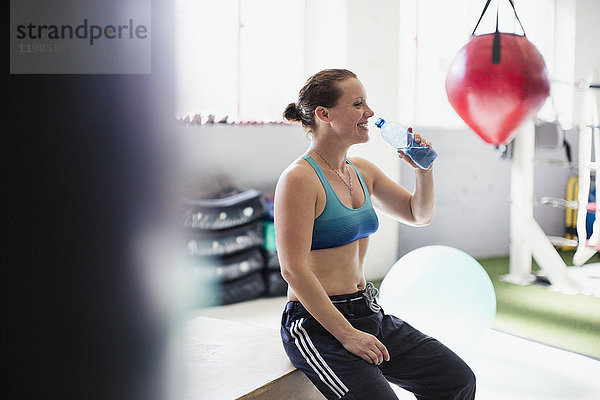 Weibliches Boxer-Trinkwasser und Ruhepfosten-Training in der Turnhalle