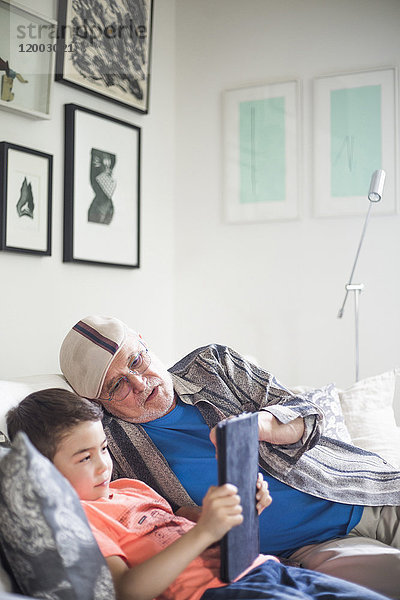 Großvater und Enkel mit digitalem Tablett zu Hause