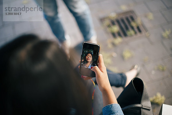 High-Winkel-Ansicht von Teenager-Mädchen  die Selfie vom Smartphone in der Stadt nehmen.