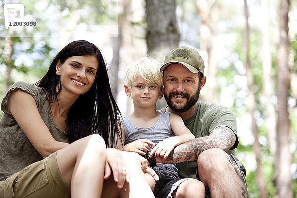 Porträt einer glücklichen Familie mit Sohn im Wald