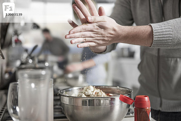 Nahaufnahme des Mannes bei der Zubereitung des Essens in der Küche