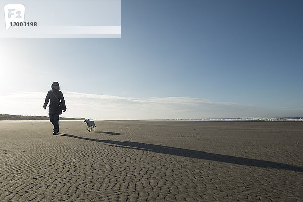Deutschland  Niedersachsen  Ostfriesland  Langeoog  Frau mit Hund am Strand