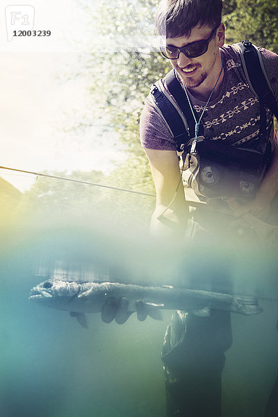 Slowenien  Mann Fliegenfischen in Soca Fluss fangen einen Fisch