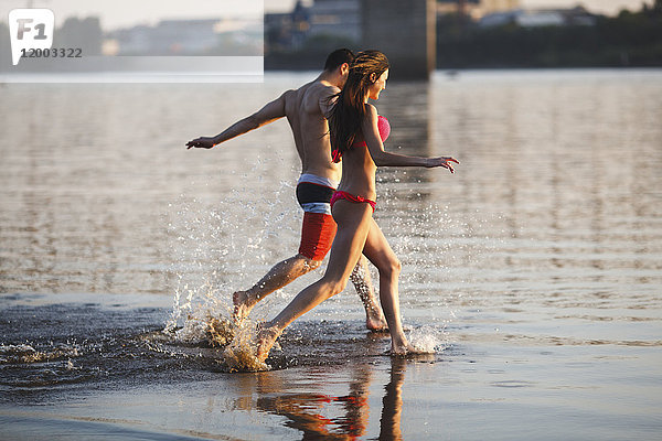 Glückliches Paar  das im Wasser läuft