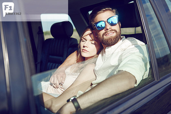 Zärtliches junges Paar entspannt im Auto