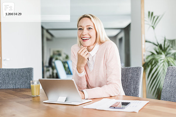 Lächelnde Geschäftsfrau mit Tablette im Büro