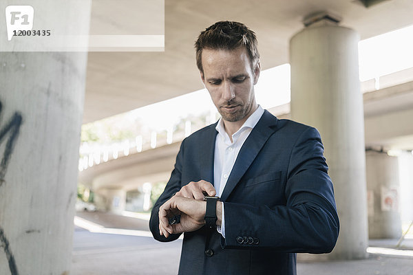 Geschäftsmann steht an der Unterführung mit smartwatch