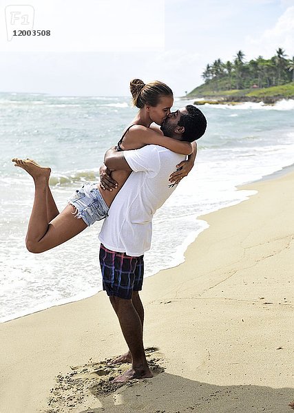 Glückliches Paar beim Küssen am Strand