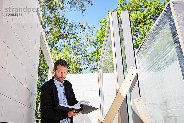 Niedrige Winkelansicht des Architekten beim Lesen des Dokuments auf der Baustelle