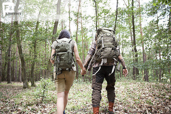 Paar mit Rucksäcken auf einer Wanderung im Wald