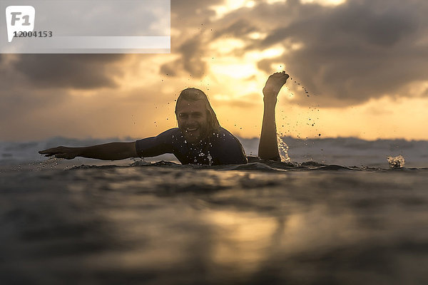 Indonesien  Bali  Surfer im Meer bei Sonnenaufgang