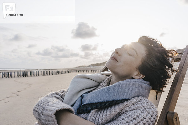 Frau entspannt im Liegestuhl am Strand
