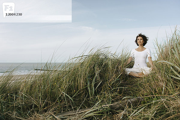 Frau beim Yoga in der Stranddüne