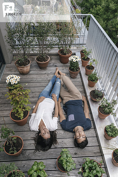 Entspanntes Paar auf dem Balkon liegend