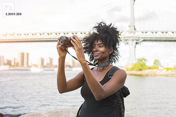 USA  New York City  Brooklyn  Frau mit Blick auf die Kamera am Wasser