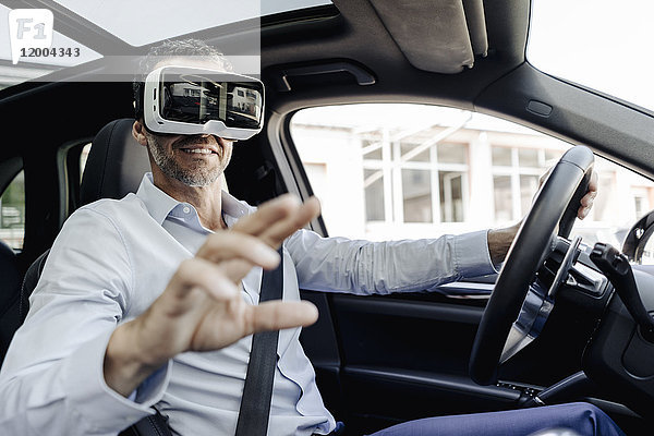 Geschäftsmann mit VR-Brille beim Autofahren