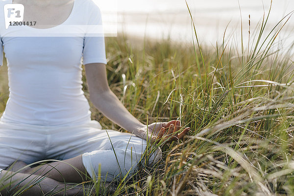 Nahaufnahme der Frau beim Yoga in der Stranddüne