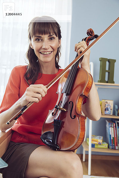 Porträt einer Frau mit Geige im Kinderzimmer