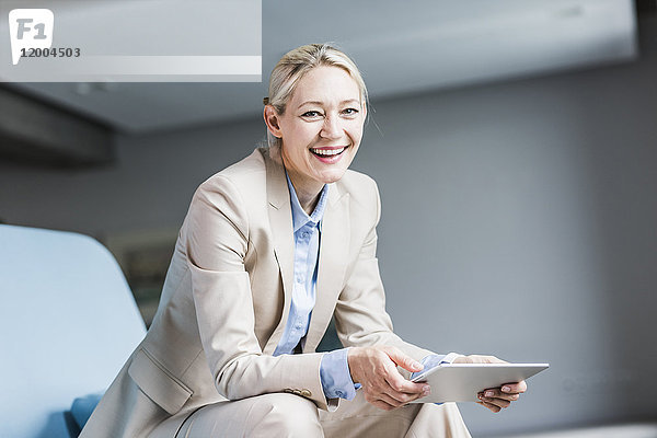 Porträt einer glücklichen Geschäftsfrau mit Tablette