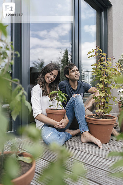 Glückliches Paar mit Pflanzen auf dem Balkon