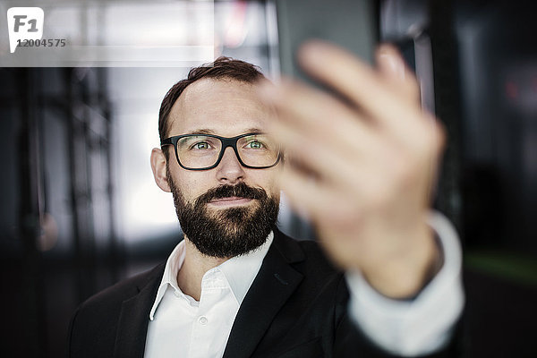 Porträt eines ehrgeizigen Geschäftsmannes  der einen Selfie nimmt.