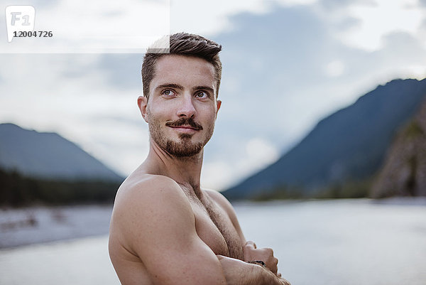 Deutschland  Bayern  Portrait eines jungen Mannes ohne Hemd in der Natur