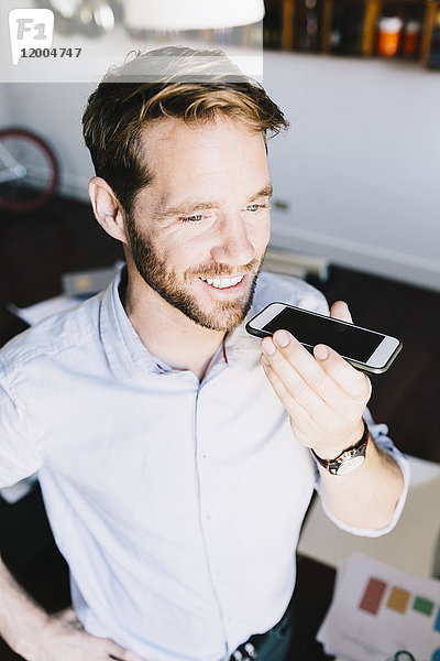 Porträt eines lächelnden Geschäftsmannes mit dem Handy
