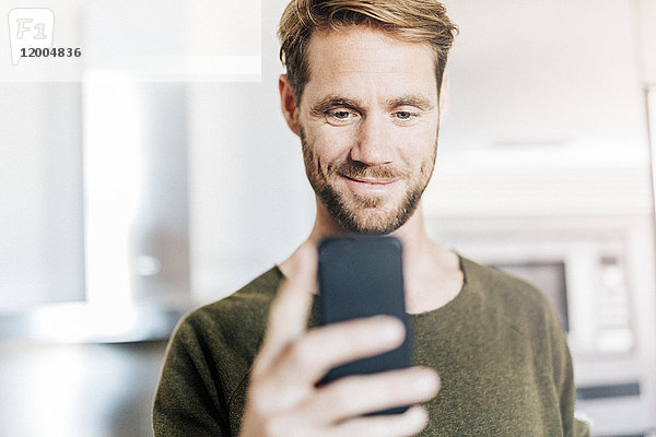 Porträt eines lächelnden Mannes auf dem Handy