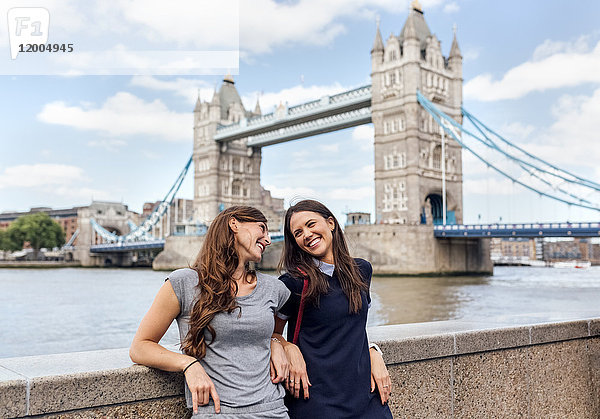 UK  London  zwei lächelnde Frauen in der Nähe der Tower Bridge