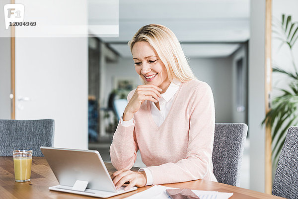 Lächelnde Geschäftsfrau mit Tablette im Büro