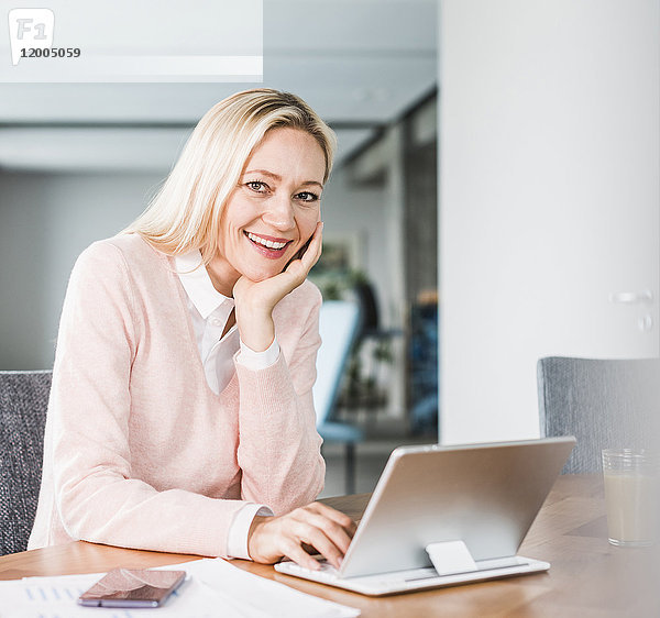 Porträt einer lächelnden Geschäftsfrau mit Tablette im Büro
