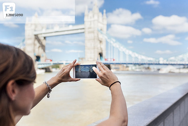 UK  London  Frau beim Fotografieren der Tower Bridge
