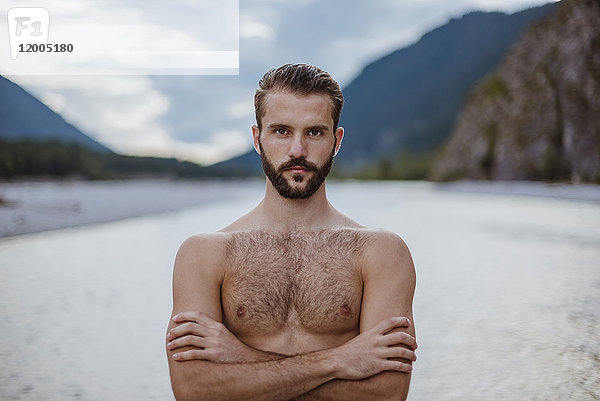 Deutschland  Bayern  Portrait eines jungen Mannes ohne Hemd in der Natur