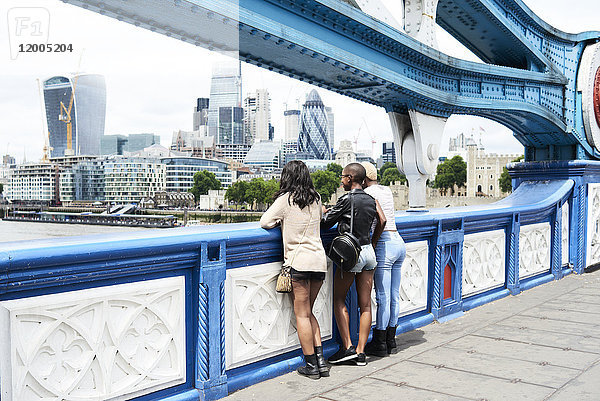 UK  London  Rückansicht von drei Freunden mit Blick auf die Skyline