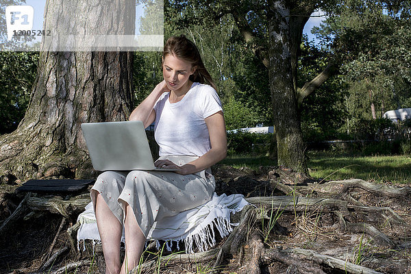 Junge Frau mit Laptop im Wald