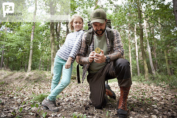 Vater und Tochter mit Kompass im Wald