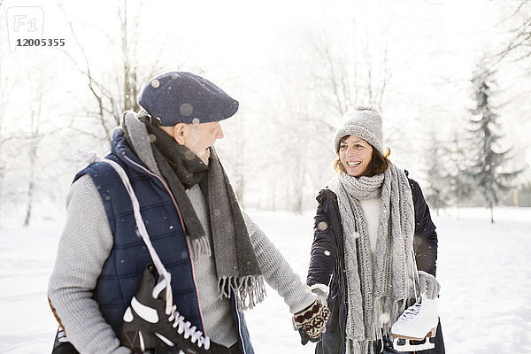 Seniorenpaar mit Schlittschuhlaufen in der Winterlandschaft