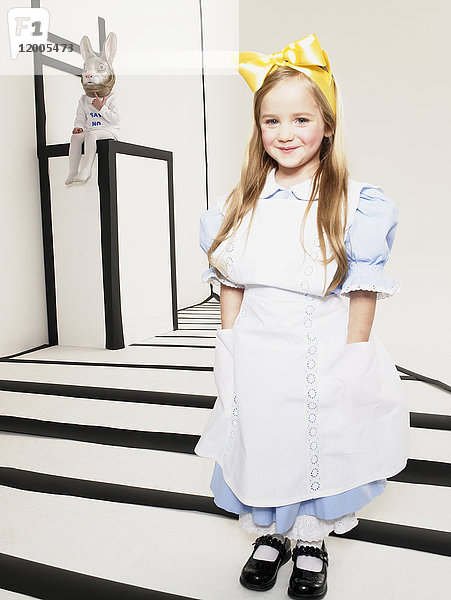 Porträt eines lächelnden kleinen Mädchens  verkleidet als Alice im Wunderland