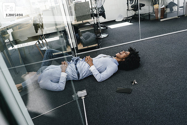 Junge Frau im Büro auf dem Boden liegend