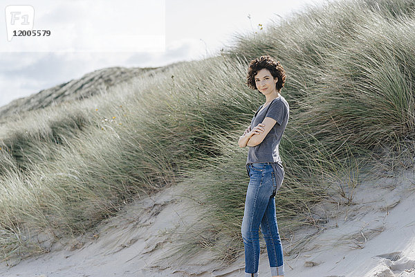Porträt einer selbstbewussten Frau  die in der Stranddüne steht.