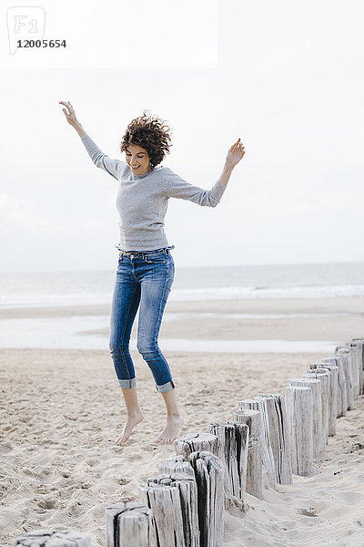 Glückliche Frau beim Springen am Strand