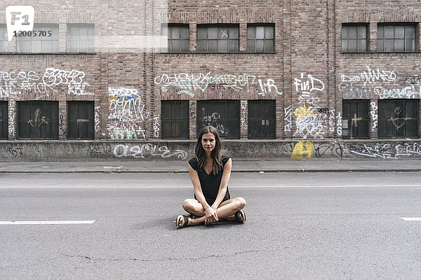 Frau auf der Straße sitzend