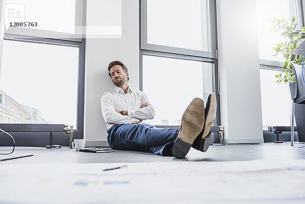 Geschäftsmann entspannt auf dem Boden seines Büros